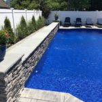 gray pool with blue stone rock face and grey stone veneer